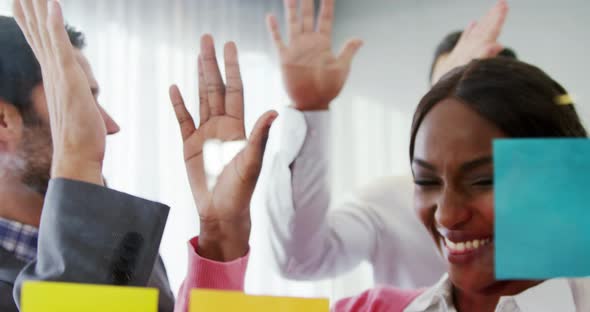 Businesspeople giving high five to each other