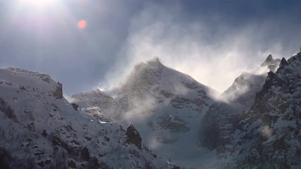 Timelapse on a Telephoto Lens of Snowcapped Peaks of High Mountains with Snow Blowing From the Peaks