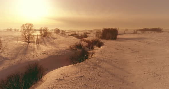 Aerial View of Cold Winter Landscape Arctic Field Trees Covered with Frost Snow Ice River and Sun