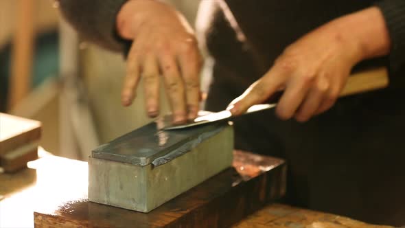 Bladesmith grinding a knife on grindstone