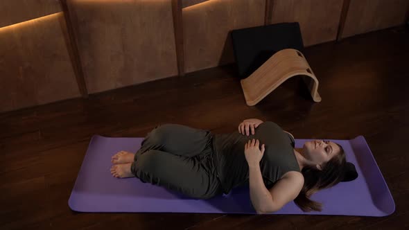 a Woman is Lying on the Floor on a Sports Mat