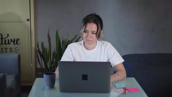 Businesswoman working on laptop computer at home. Woman using laptop on kitchen