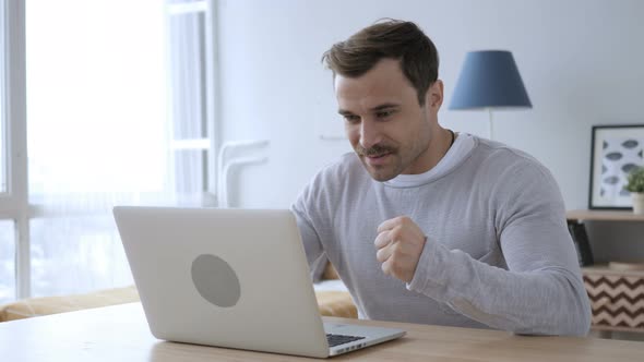 Excited Adult Man Celebrating Success, Working on Laptop