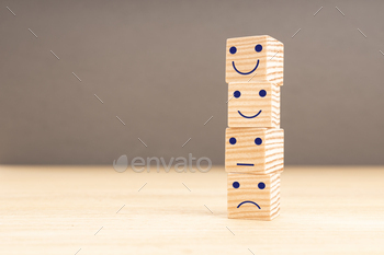 sfaction survey concept. Face emoticon on stacked wooden blocks. Copy space