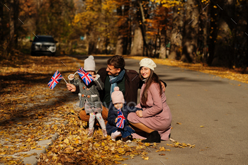 itish flags in autumn park.  Britishness celebrating UK. Two kids.