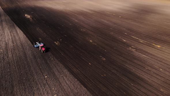 Tractor Plows Ground on Cultivated Farm Field