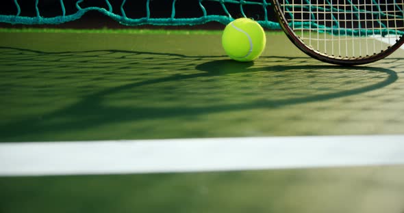 Tennis ball and racket against net in court 4k