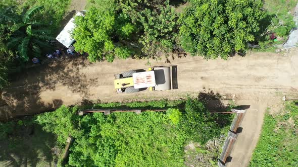 A steamroller driver flattening the road surface for construction.