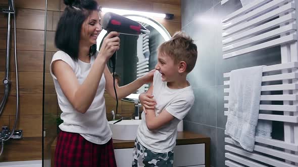 Mother and Son Fooling Around in the Bathroom While Drying Hair with Hair Dryer