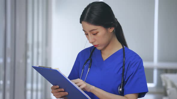 Young Woman Doctor Checking Reports in Hospital