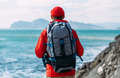 A man in tourist gear on the background of the sea. The concept of travel and an active lifestyle - PhotoDune Item for Sale