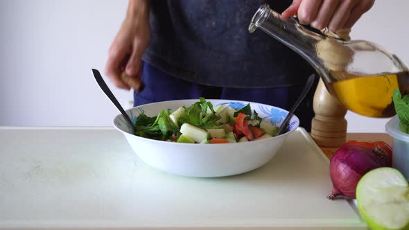 Pouring Olive Oil On Plate Of Salad For Breakfast. - close up