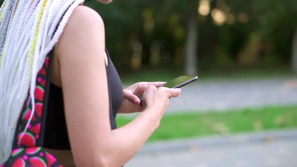 Unrecognizable Girl with Backpack Messaging Using Smartphone