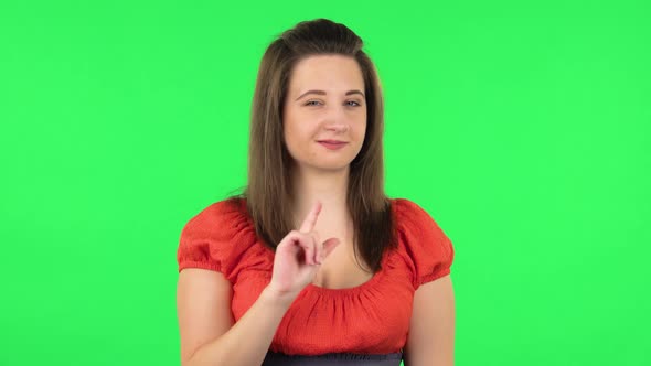 Portrait of Cute Girl Seductively Smiling and Gesture Threatens By Shaking Her Index Finger. Green