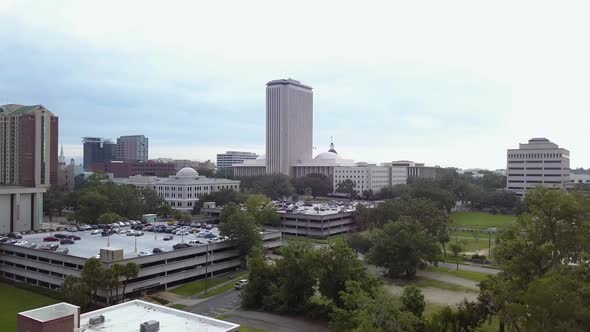 Rising to reveal downtown Tallahassee skyline and Florida state capitol, aerial, pedestal.