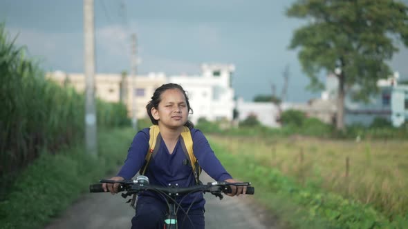 An Indian Kid Cycling on a Road Near a Sugarcane Field in a Rural Area of Uttarakhand India