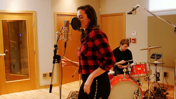 Woman singing in recording studio