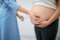 Close up of doctor measuring tummy of pregnant woman - PhotoDune Item for Sale