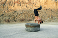 Active guy balancing on tyres while training outdoors - PhotoDune Item for Sale