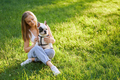 Smiling woman hugging french bulldog on grass. - PhotoDune Item for Sale