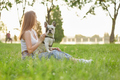 Woman sitting with french bulldog on grass. - PhotoDune Item for Sale