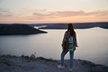 Female traveler with backpack standing on hill at Bakota bay - PhotoDune Item for Sale