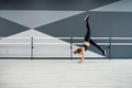 Female dancer practicing wheel jump in dance hall. - PhotoDune Item for Sale
