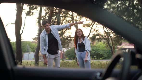 Positive Couple Explaining Route to Traveler Talking Gesturing Smiling