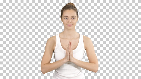 Young yogi woman practicing yoga making namaste gesture, working