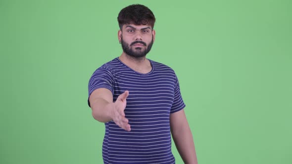 Young Overweight Bearded Indian Man Giving Handshake