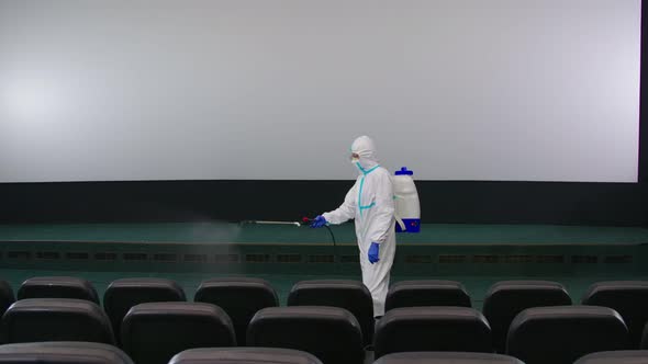 Worker Cleaning Cinema Hall with Against Coronavirus