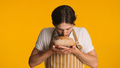 Male baker wearing apron enjoying aroma of bread standing against a colorful background - PhotoDune Item for Sale