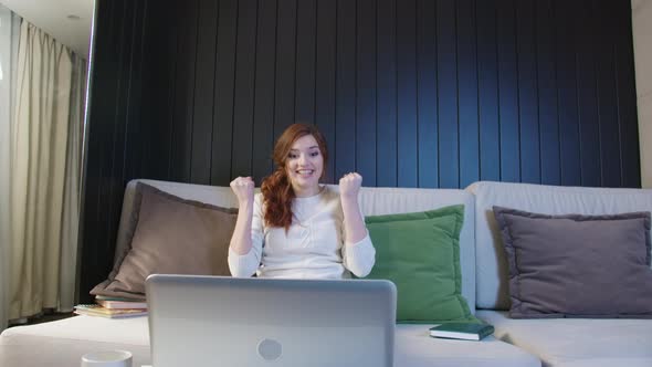 Young Woman Customer Celebrating Winning Bid Or Getting an Ecommerce Shopping Offer On Laptop