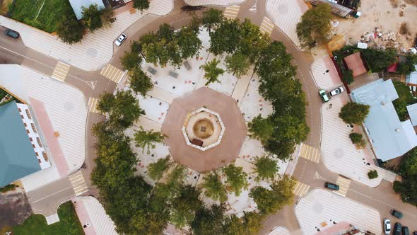 Large Circular Asphalt Road Junction with Green Trees Aerial