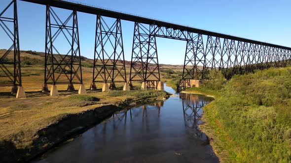 Battle River Trestle on sunny day. Aerial 4K Drone footage. Green Bushland and forests. Flyover blue