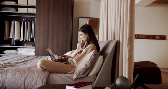 Young Beautiful Woman Using Laptop Apps Wear Pyjama Sitting in Cozy Bed