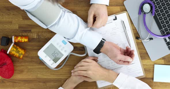 Doctor Measures Patient Blood Pressure in Medical Office