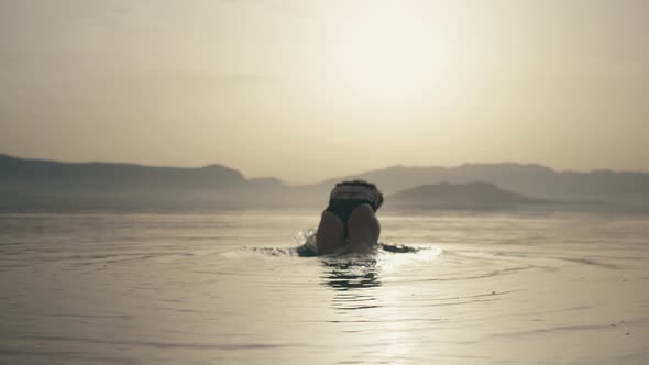 Slow Motion Video of a Girl Diving Into the Sea at Sunset