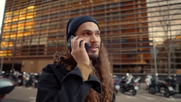 Portrait of Long Haired Hipster Walking on Street in Modern City