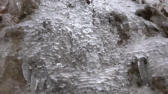 Water and Air Bubbles Flowing Through the Glassy Transparent Ice