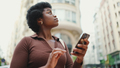 African American young thoughtful woman looking for destination using navigation on smartphone - PhotoDune Item for Sale