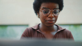 Close up Afro haired woman in glasses looking serious working on - PhotoDune Item for Sale