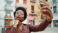 Afro curly girl wearing glasses  sending kiss taking selfie on t - PhotoDune Item for Sale