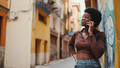 African girl in glasses talking over mobile phone while walking - PhotoDune Item for Sale