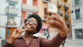 Cheerful African American curly woman taking selfie on street. P - PhotoDune Item for Sale