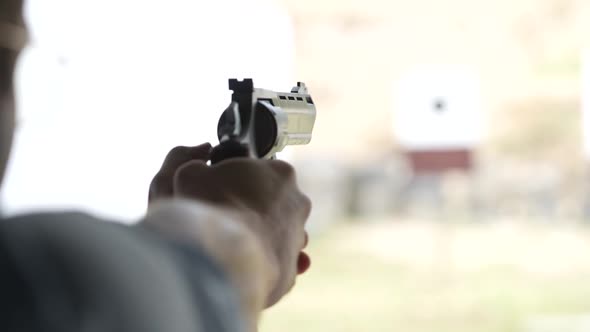 Man shoots with a revolver at targets on the shooting range. Slow motion