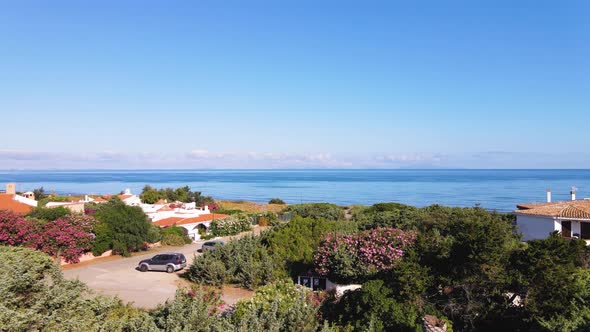 Aerial panoramic drone view of coastline and nearby village in Sardinia, Italy