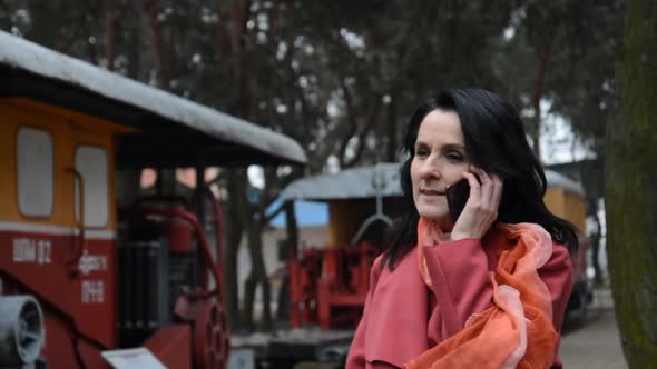 Portrait of an Adult Woman Talking on the Phone in an Industrial Area