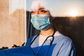 Young female doctor looking through window - PhotoDune Item for Sale