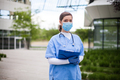 Young female EMS key worker doctor in front of healthcare ICU facility - PhotoDune Item for Sale